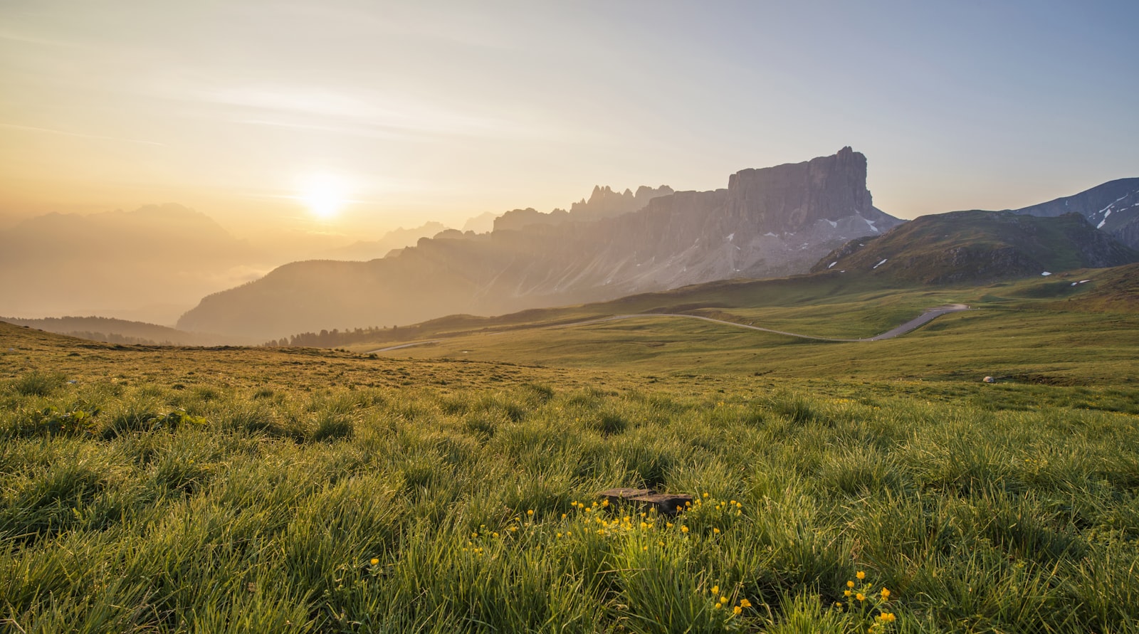 Amanecer sobre praderas y cordillera de montaña
