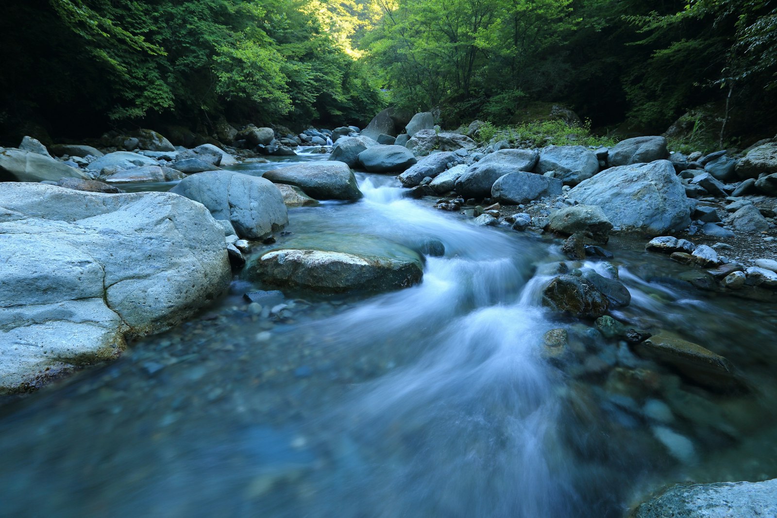 Río de montaña corriendo entre piedras de agua cristalina